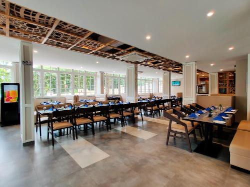 a large dining room with tables and chairs at Pushpam Sanskruti Resort Karjat- Pure Veg in Karjat