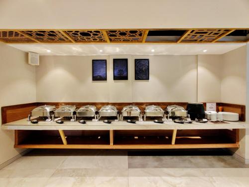 a row of pots and pans on a counter at Pushpam Sanskruti Resort Karjat- Pure Veg in Karjat