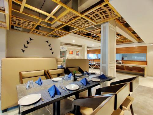 a dining room with a long table and birds on the wall at Pushpam Sanskruti Resort Karjat- Pure Veg in Karjat
