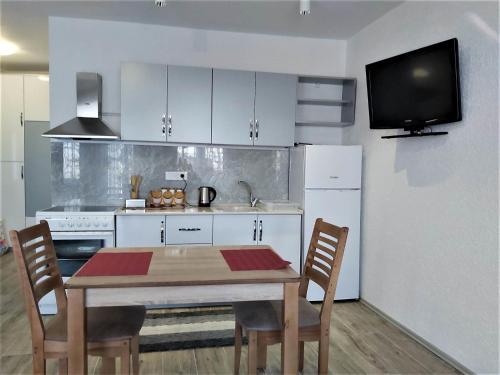 uma cozinha com mesa e cadeiras e uma televisão em Studio Apartment - Prizren em Prizren