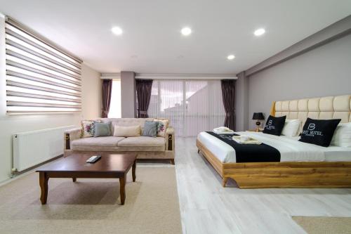 a bedroom with a bed and a couch and a table at Best Hotel Pendik in Istanbul