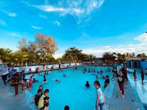 DGeting Beach Resort في تومبات: مجموعة من الناس في مسبح في حديقة مائية