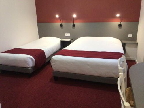 two beds in a room with red and gray walls at Hôtel Bellevue Bagnoles Normandie in Bagnoles de l'Orne