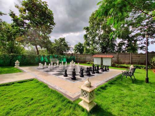 a large chessboard in a garden with a lawn at Pushpam Sanskruti Resort Karjat- Pure Veg in Karjat