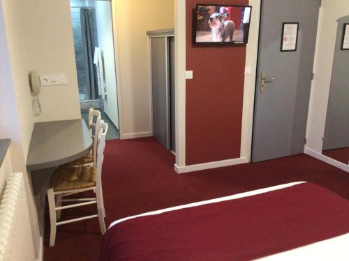 a room with a red floor and a door with a tv at Hôtel Bellevue Bagnoles Normandie in Bagnoles de l'Orne