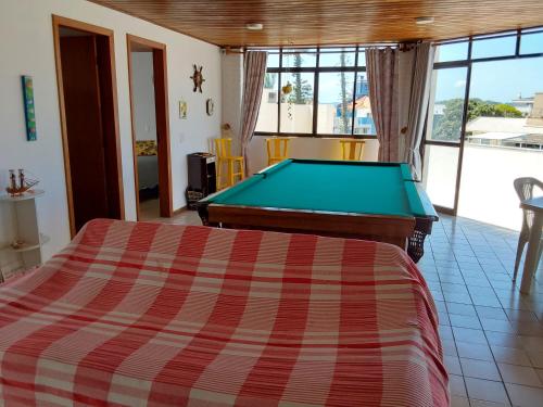 a bedroom with a pool table in a room at Apartamento em Canasvieiras perto do mar in Florianópolis