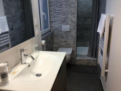 a bathroom with a sink and a toilet at Hôtel Bellevue Bagnoles Normandie in Bagnoles de l'Orne