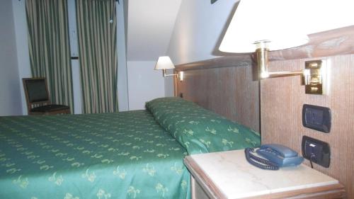 a hotel room with a bed and a phone on a table at Hotel Riviera in Arenzano