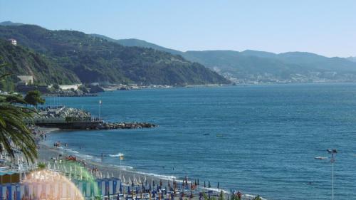 a beach with a bunch of chairs and the ocean at Hotel Riviera in Arenzano