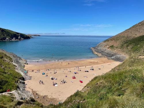 a group of people on a beach near the water at Caemorgan Mansion in Cardigan