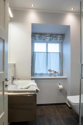 a bathroom with a sink and a window at Südernest 2 in Wyk auf Föhr