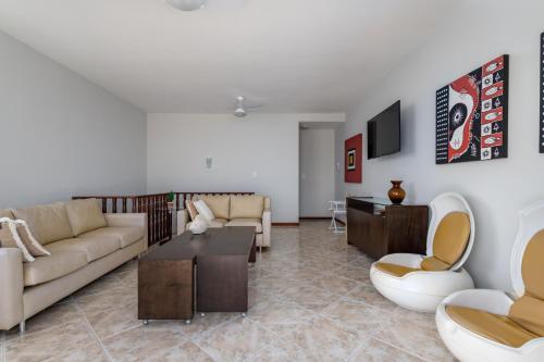 a living room with a couch and a table at Cobertura de alto padrão com vista para a Praia do Forte in Cabo Frio