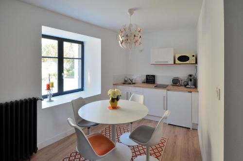 a kitchen and dining room with a table and chairs at Logement Cosy à 5mn du Futuroscope in Jaunay-Marigny