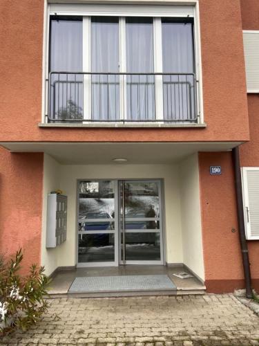 a building with a balcony on top of it at Comfort 1 and 2BDR Apartment close to Zurich Airport in Zürich