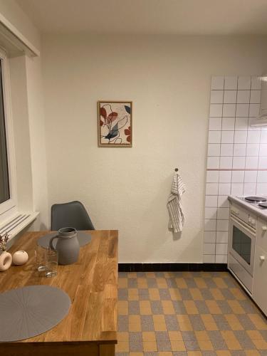 a kitchen with a wooden table and a counter top at Comfort 1 and 2BDR Apartment close to Zurich Airport in Zürich