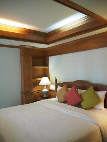 a bedroom with a large bed with four pillows at Rich Lanna House in Chiang Mai