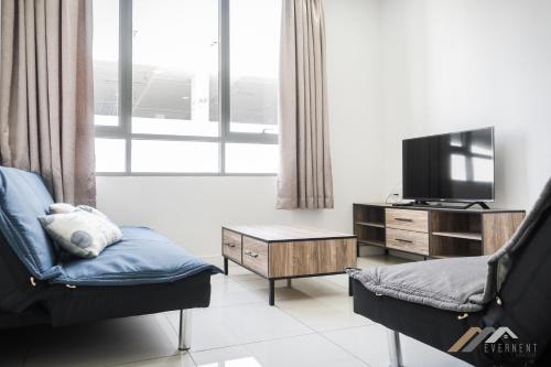 a living room with a tv and a chair and a table at Marina Times Square Homestay by Evernent in Miri