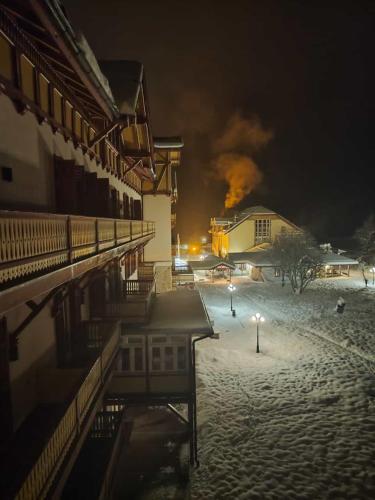 a building with fire in the background at night at Ploner villaggio Turistico in Dobbiaco