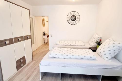 a white bedroom with two beds and a mirror at Schönes Apartment in Erkrath, Nähe Düsseldorf in Erkrath