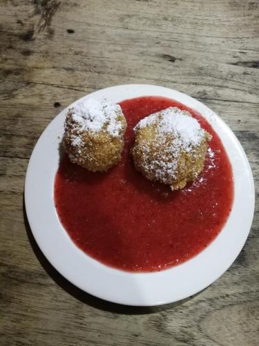 a plate with two donuts on a red sauce at Nuestro Bosque I in Tena