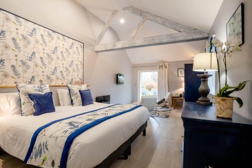 a bedroom with a large bed with blue and white pillows at Domaine De L´Oiseau in Gergy