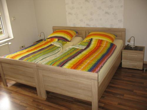 a bed with colorful blankets on top of it at Haus Eichengrund in Papenburg