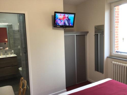 a room with a television on the wall at Hôtel Bellevue Bagnoles Normandie in Bagnoles de l'Orne
