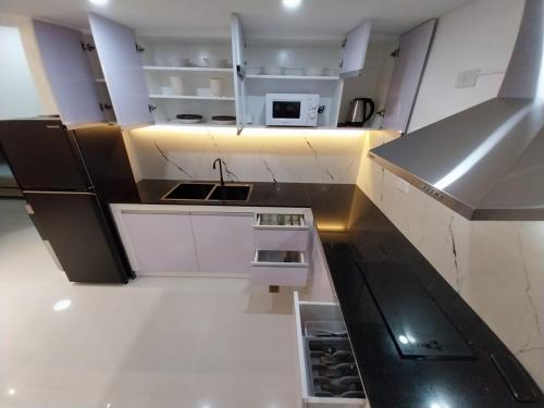 a small kitchen with white cabinets and a sink at 88 Gibraltar (Mines View) in Baguio