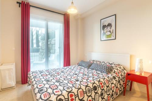 a bedroom with a bed and a table and a window at 2187-Lovely 2bedrooms with pool and playground in Manilva