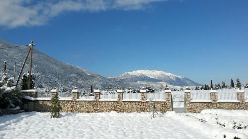 a fence covered in snow with mountains in the background at Xenios Petritis in Levádeia