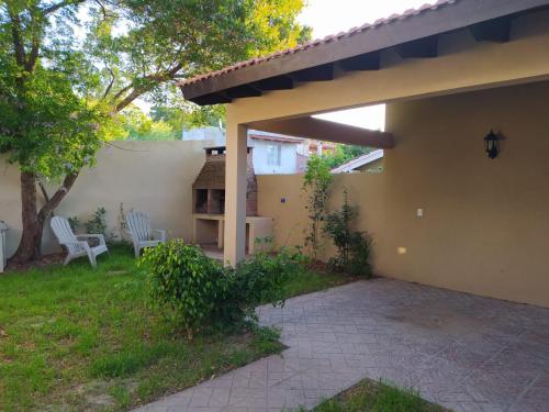 un patio de una casa con 2 sillas y un árbol en Danimar en San Clemente del Tuyú