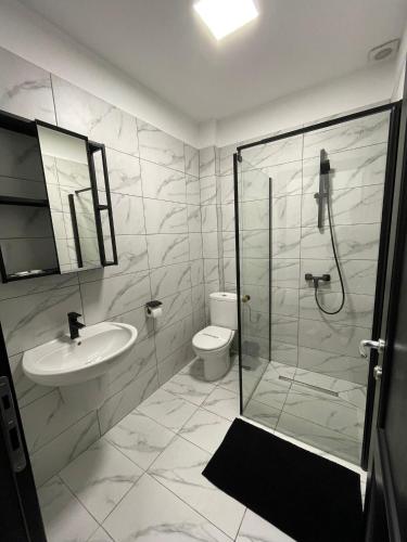 ein Badezimmer mit Dusche, Waschbecken und Toilette in der Unterkunft Hotel Rivoli in Bukarest