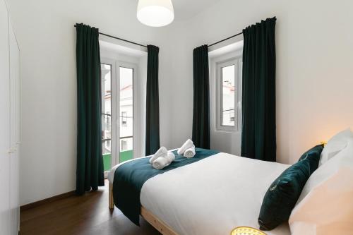 une chambre avec un lit et deux fenêtres dans l'établissement Old Town House, à Peniche