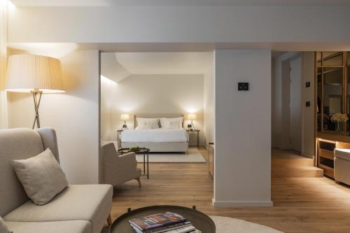 a living room with a bed and a couch and a table at Casa da Companhia Hotel & Spa, Vignette Collection by IHG in Porto