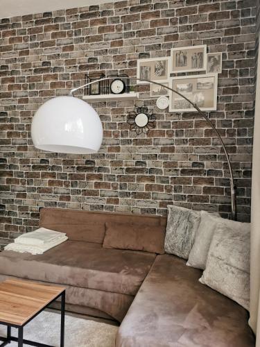 a living room with a couch and a brick wall at Ferienwohnung Luise mit separater Küche in Naumburg