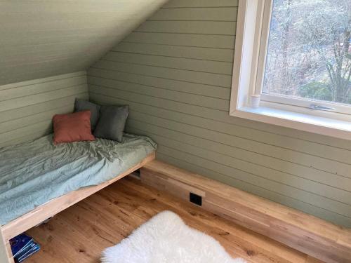 een klein bed in een kamer met een raam bij Holiday home SVEIO IV in Sveio