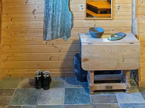 una camera con una parete in legno, un tavolo e una ciotola di Holiday home byrknesøy a Ånneland