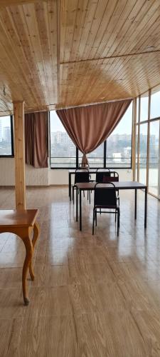 a large room with tables and chairs and windows at Astoria Sky in Tbilisi City