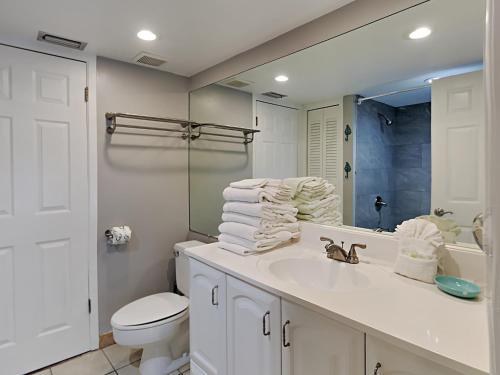 W łazience znajduje się umywalka, toaleta i lustro. w obiekcie Sandpiper Cove 2015 w mieście Destin