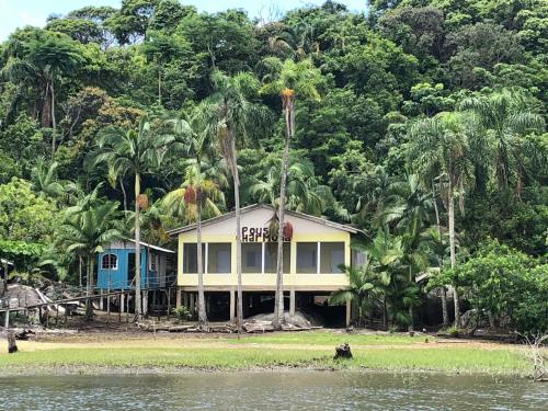 una casa en la orilla de un cuerpo de agua en POUSADA CHARMOSA en Superagui