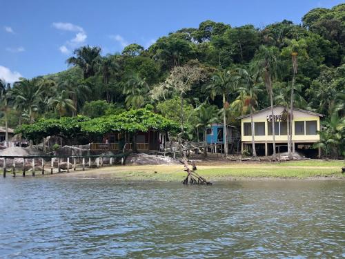 uma pessoa de pé na costa de uma massa de água em POUSADA CHARMOSA em Superagui