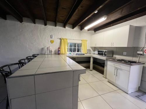 a kitchen with white cabinets and a counter top at Le Soleil in Graskop