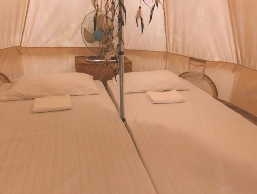 two beds in a tent with towels on them at Mad Monkey Hostel Nacpan Beach in El Nido