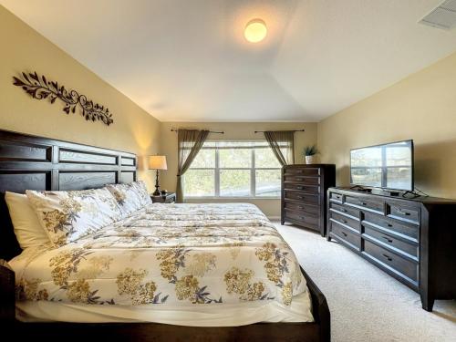 1 dormitorio con 1 cama grande y TV en This amazing 6 Bedroom property with a lake view villa, en Orlando