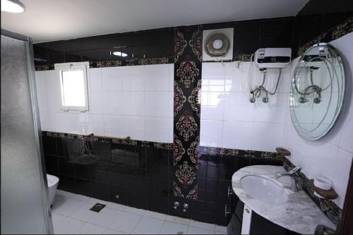 ein schwarzweißes Bad mit einem Waschbecken und einem WC in der Unterkunft فيلا درة العروس in Durrat Al-Arus