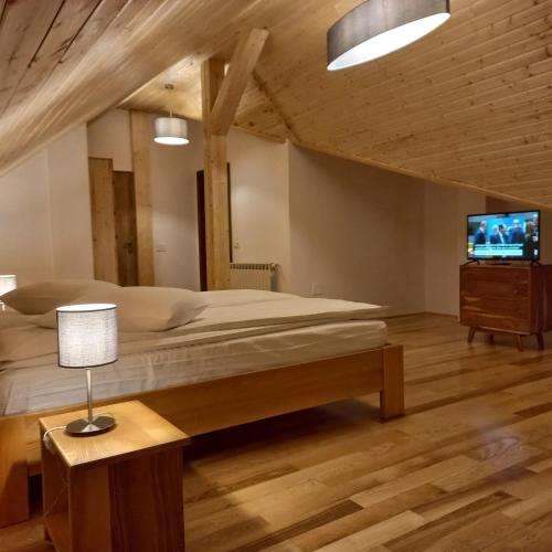 a bedroom with a large bed and a tv at Cedra in Predeal