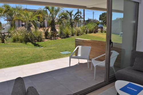 a living room with a sliding glass door and a table and chairs at SYRAH Premium B2 - Vistas al Parque by depptö in Punta del Este
