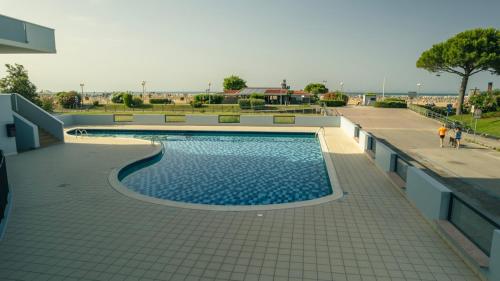 uma piscina ao lado de um edifício em Residence Itaca em Bibione
