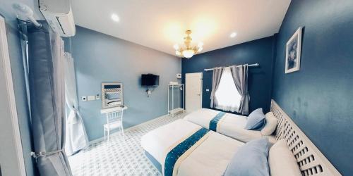 a bedroom with blue walls and a bed in it at ลิลล์ลดา บูติค โฮเต็ล in Ban Na Oi