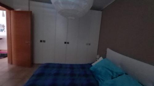ein kleines Schlafzimmer mit einem Bett mit einer blauen Decke in der Unterkunft Sasso moro sweet dream in  Monvalle 
